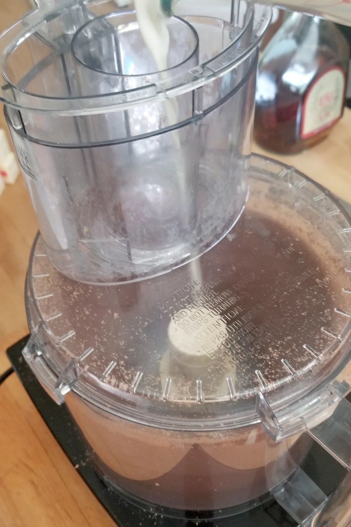 hot cream pouring into a food processor filled with milk chocolate