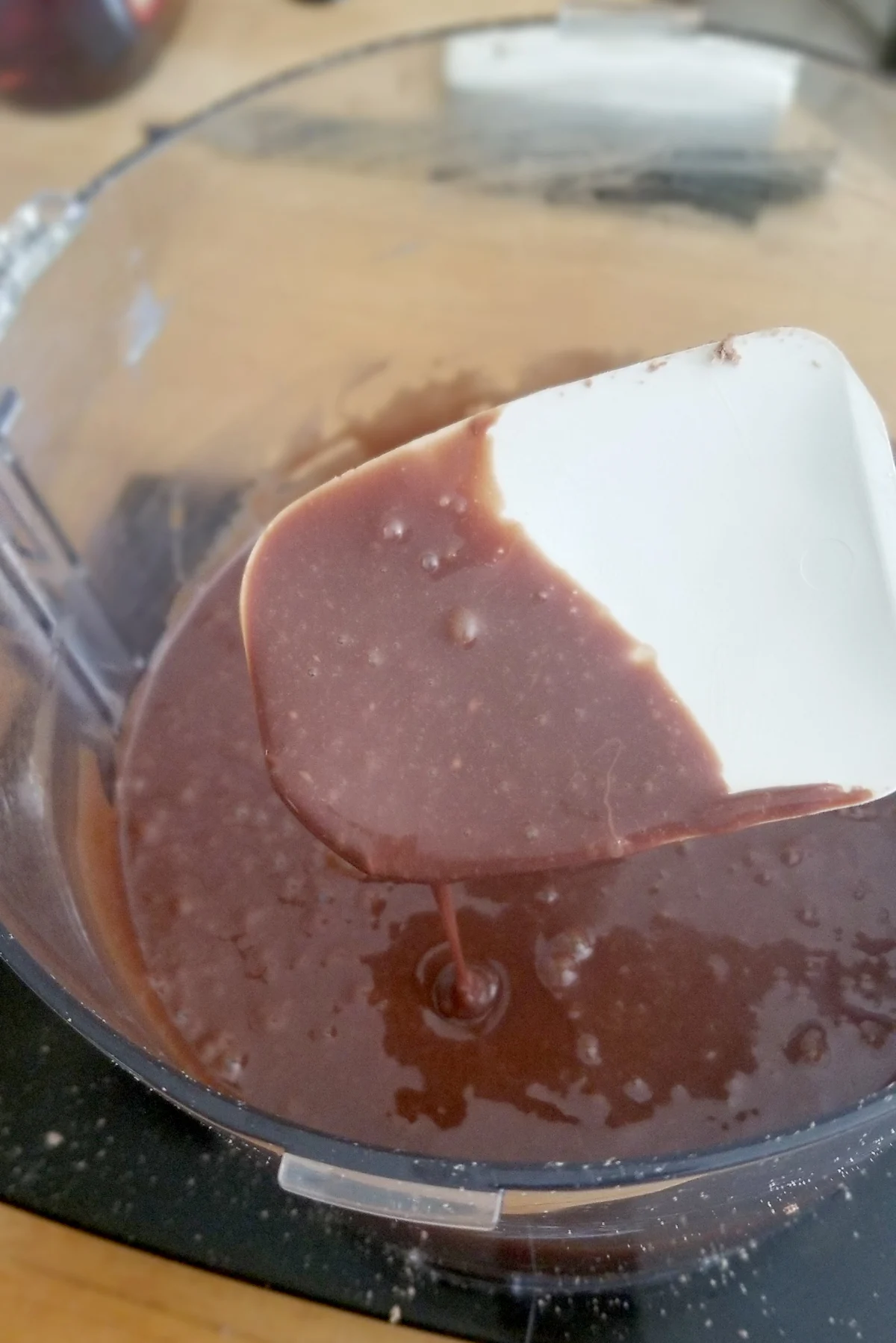 a spatula covered with liquid milk chocolate ganache