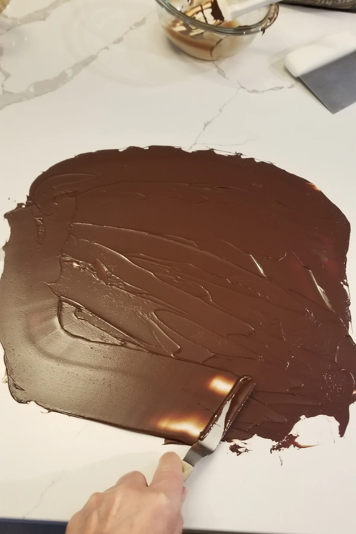 spreading chocolate into a thin layer on a work surface