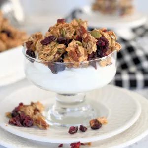 a glass bowl with yogurt and sourdough granola.