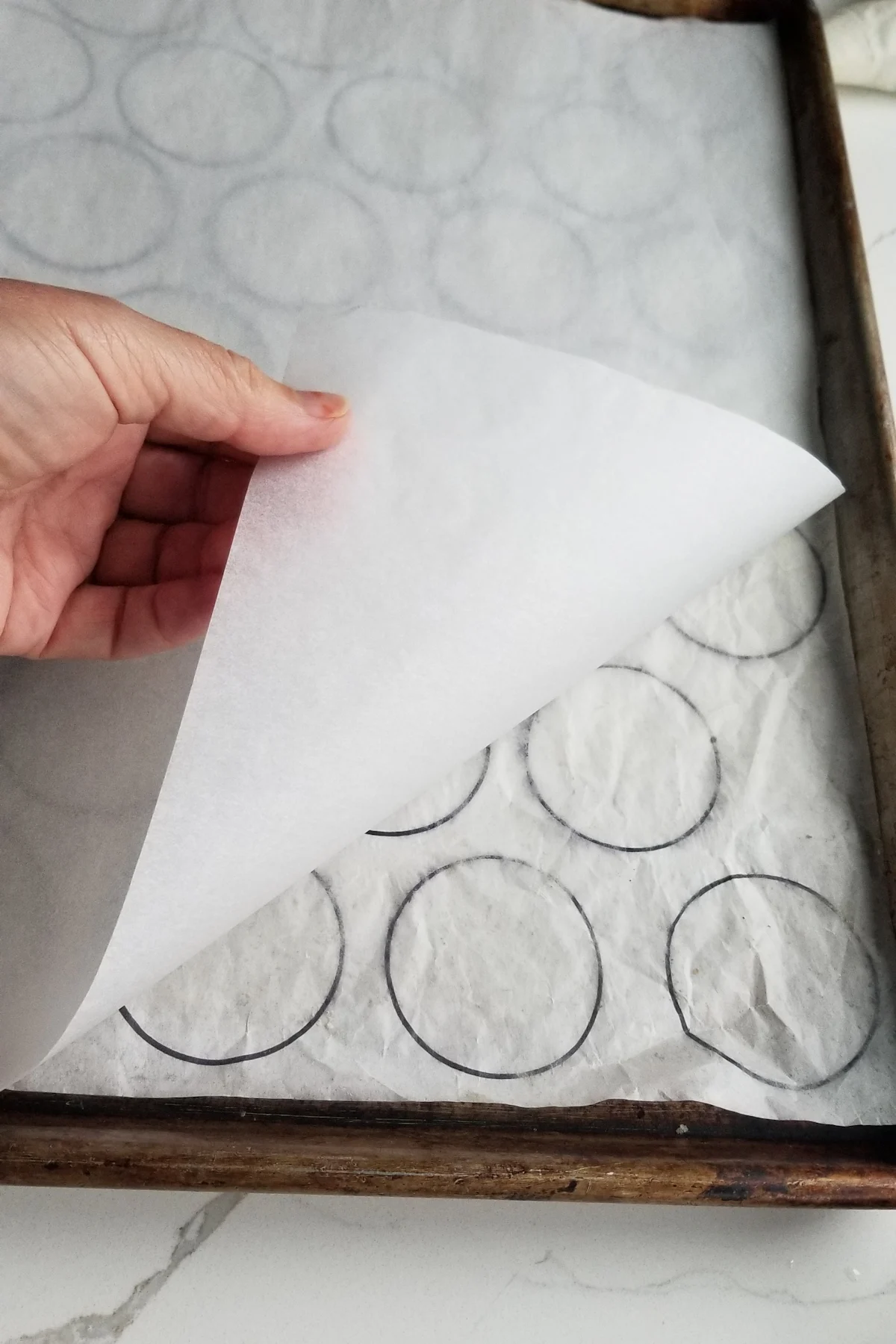 a baking sheet with parchment paper over a cookie piping guide