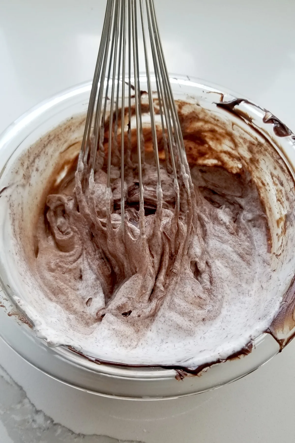 a bowl of chocolate with cream being added