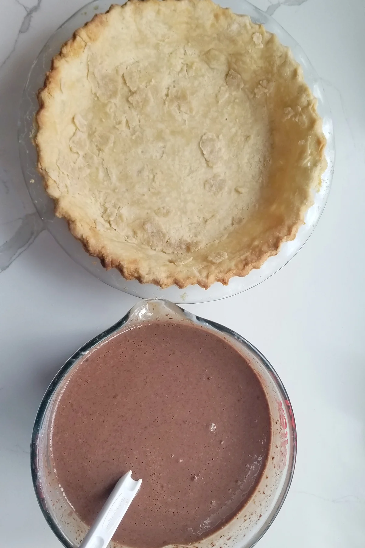 a prebaked pie shell and a bowl of chocolate custard mix.