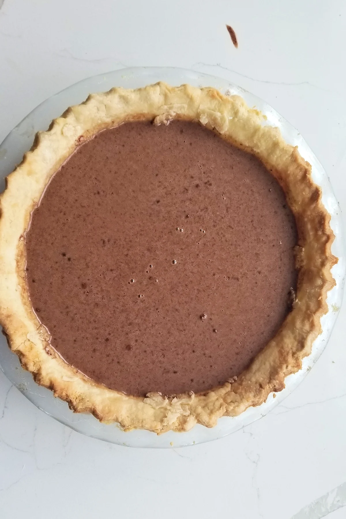 a pie crust filled with chocolate custard batter.
