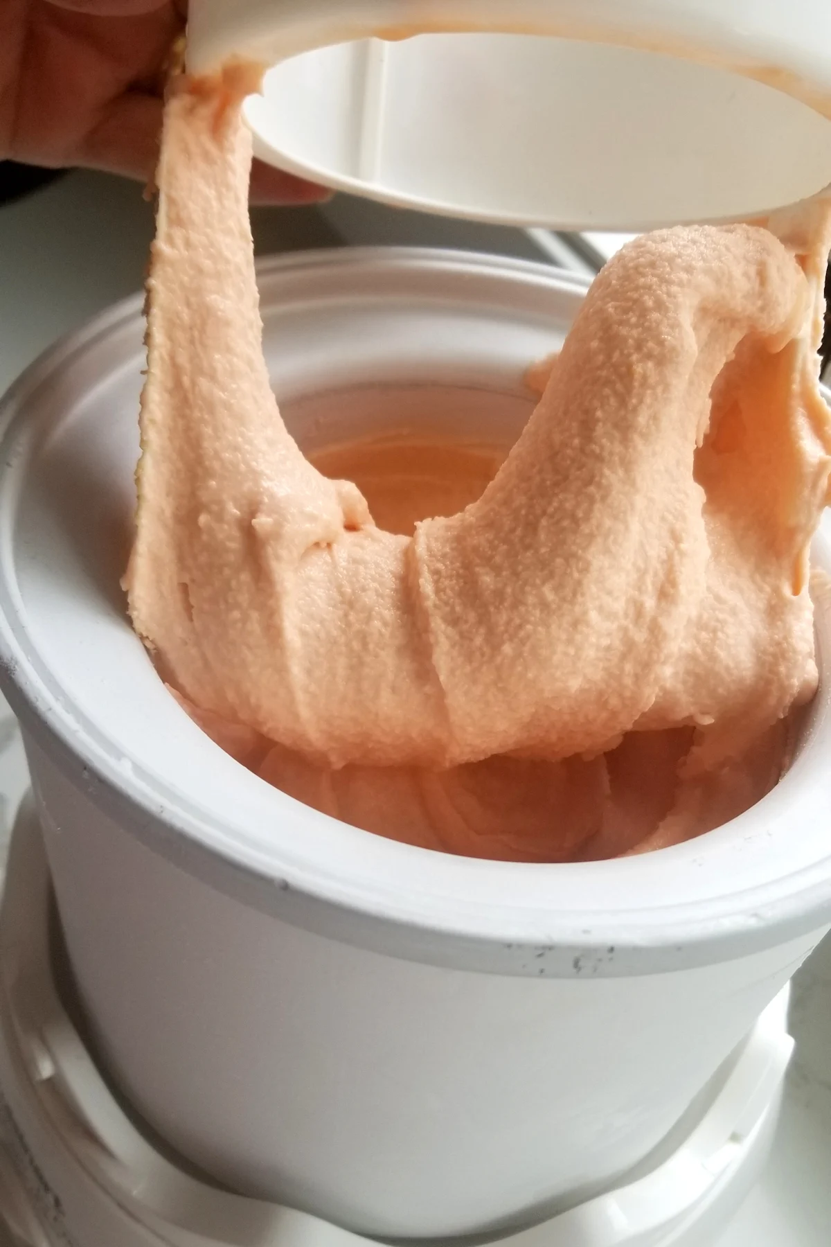 a closeup shot of ice cream coming out of an ice cream maker.