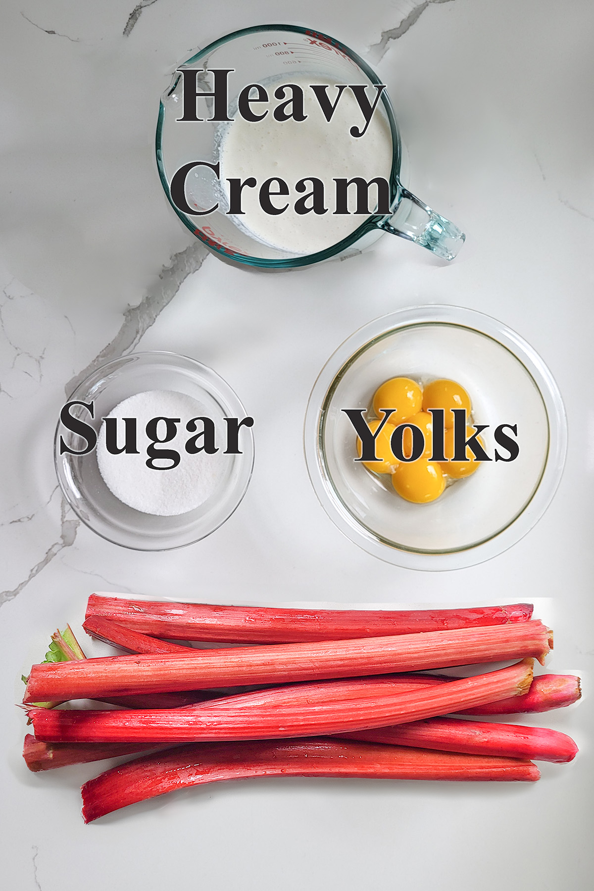 ingredients for rhubarb ice cream in glass bowls on a white surface.