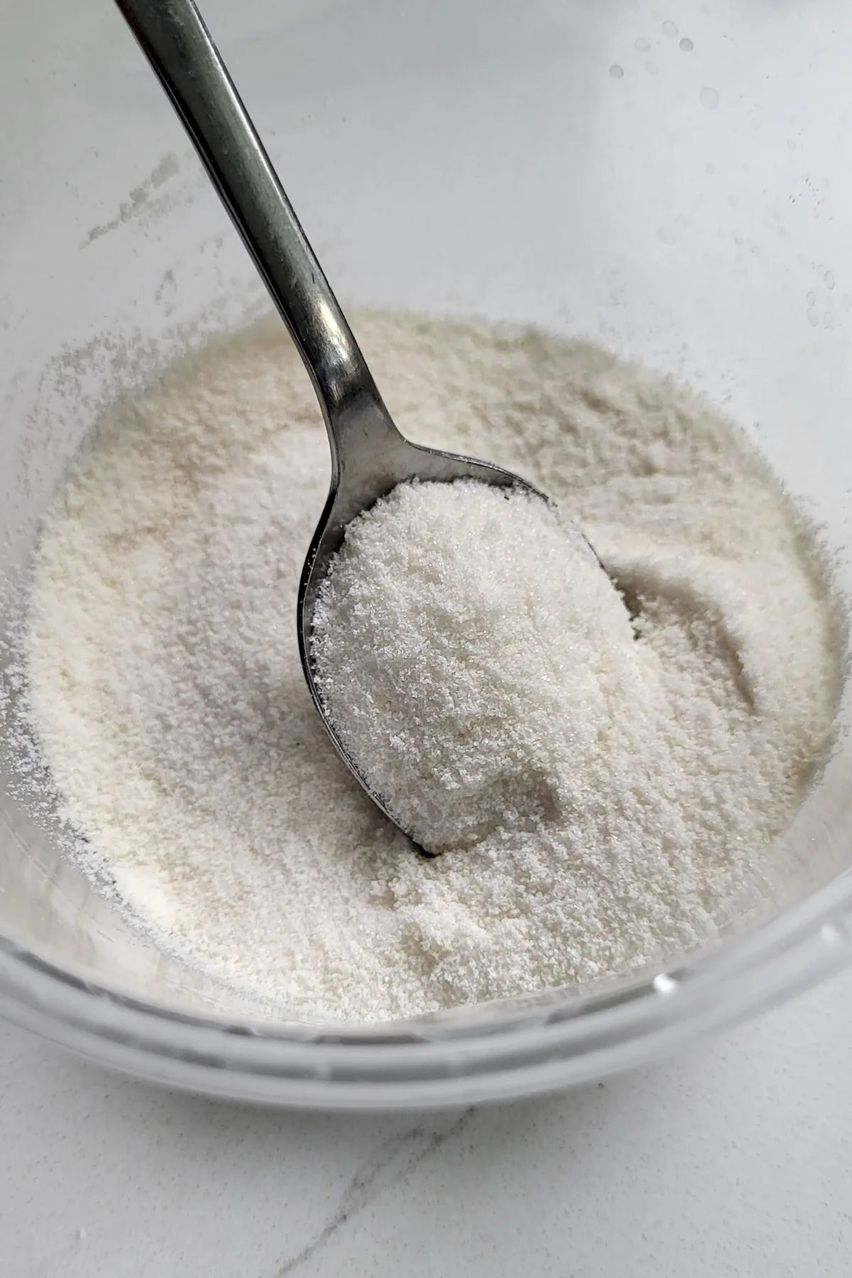 a bowl of sugar with a spoon