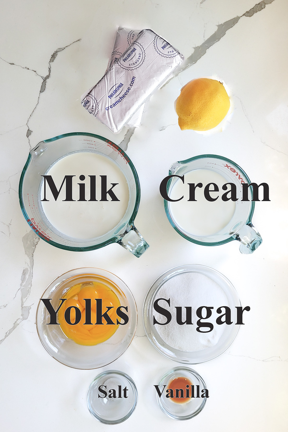 ingredients for cream cheese ice cream in glass bowls on a white surface.