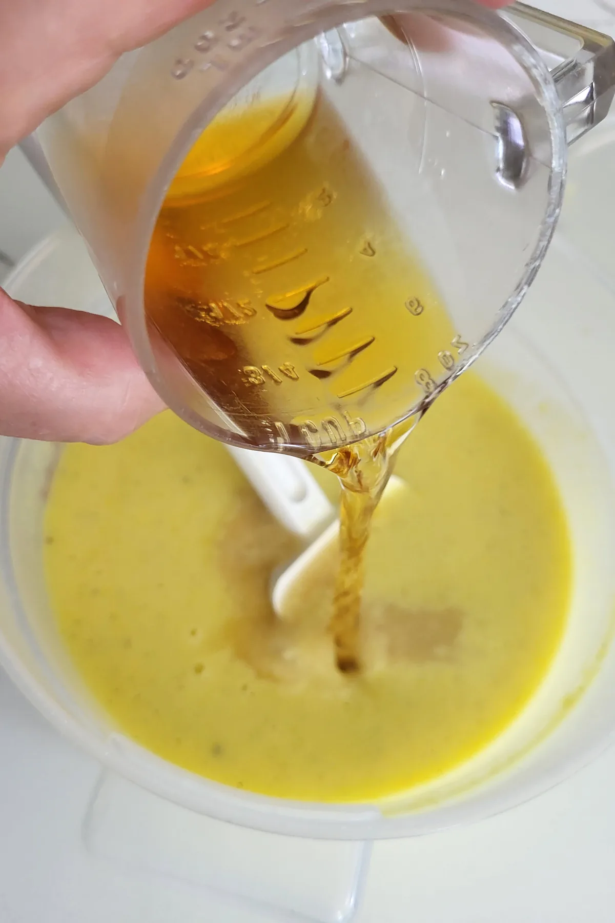 a cup pouring bourbon into custard