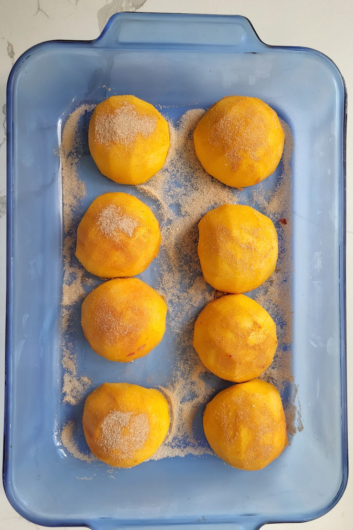 peach halves in a glass baking dish.
