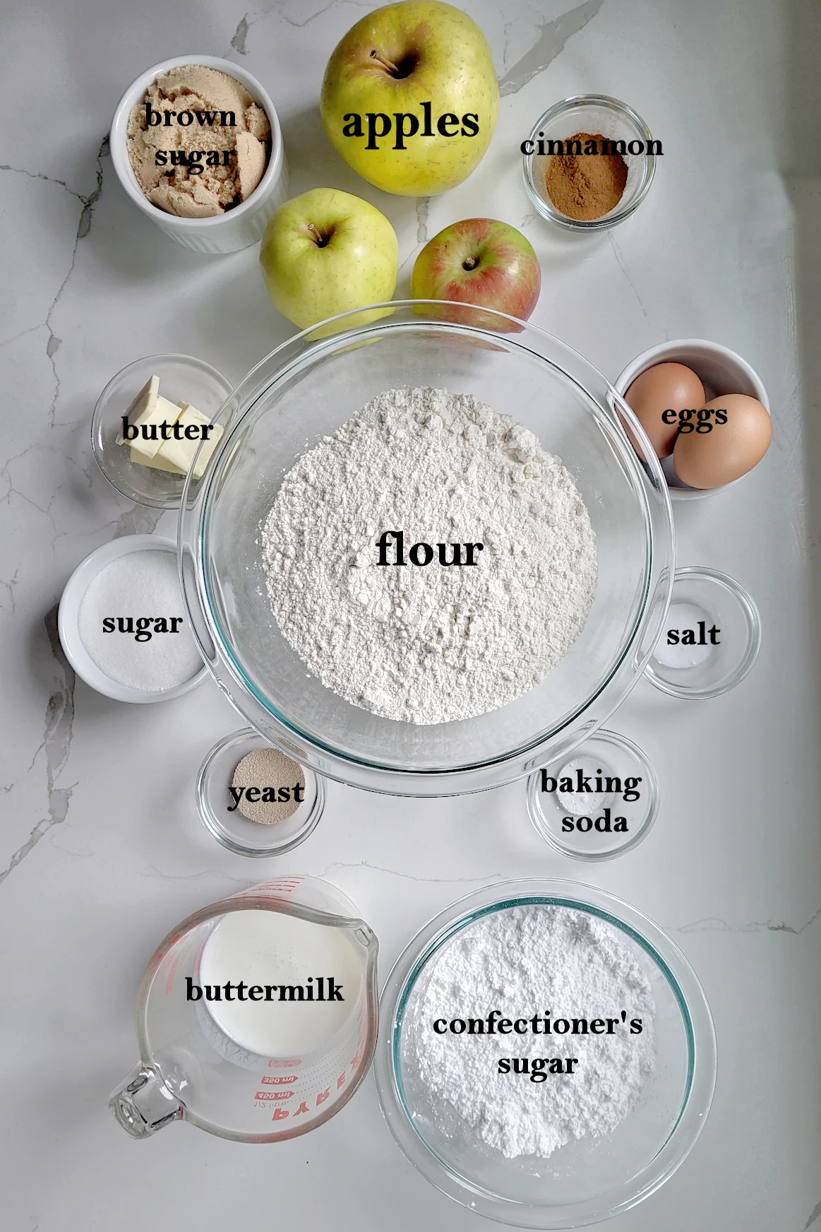 baking ingredients in bowls on a white surface.