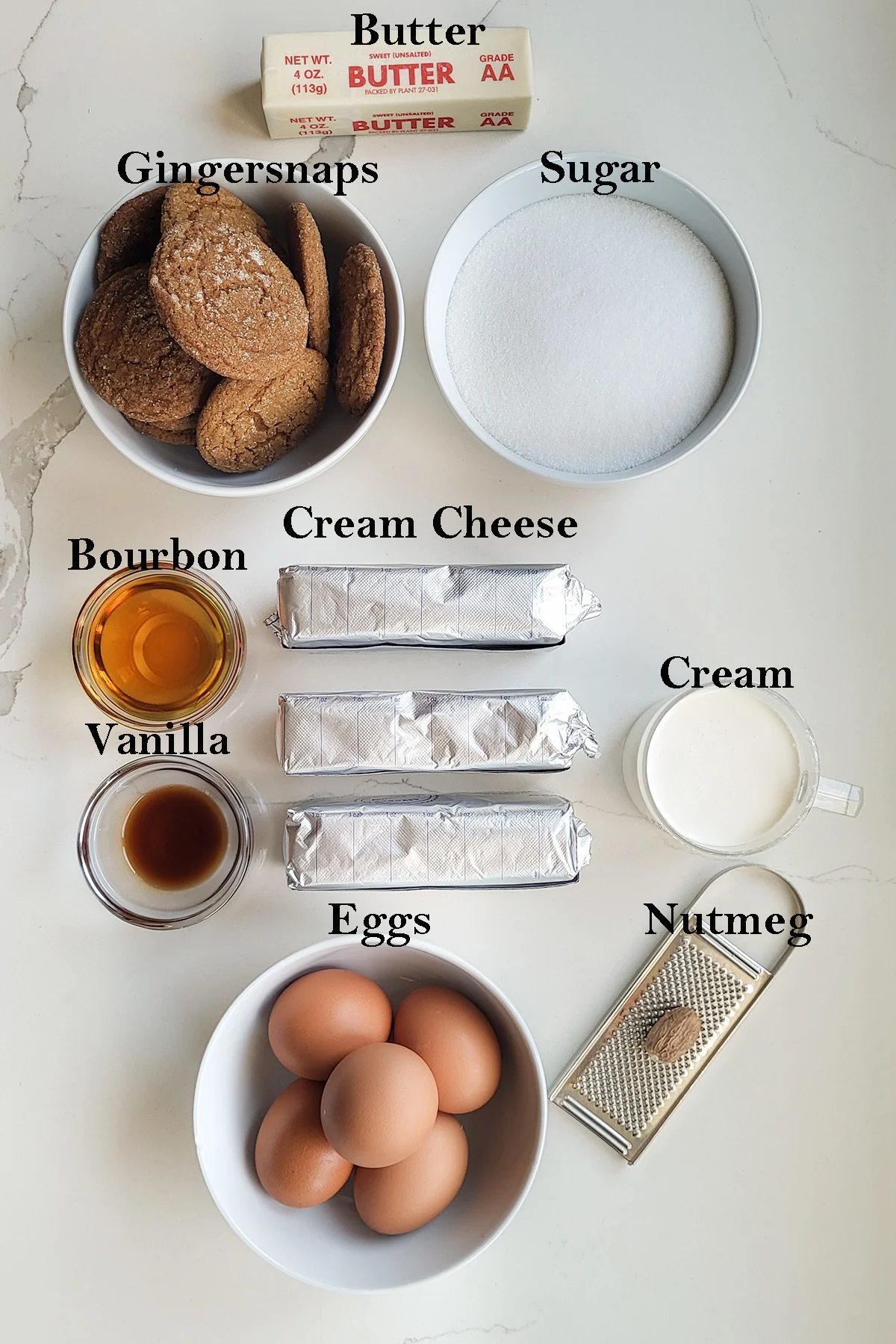 ingredients for eggnog cheesecake in bowls. Text overlay on the photo.