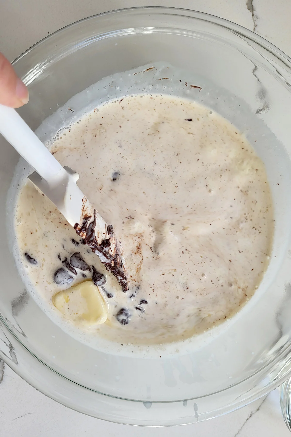 a bowl of chocolate and cream with a spatula