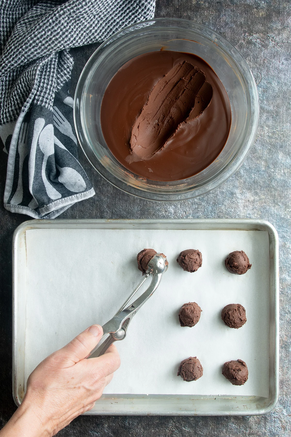 a bowl of ganache and a tray of ganache truffles being scooped