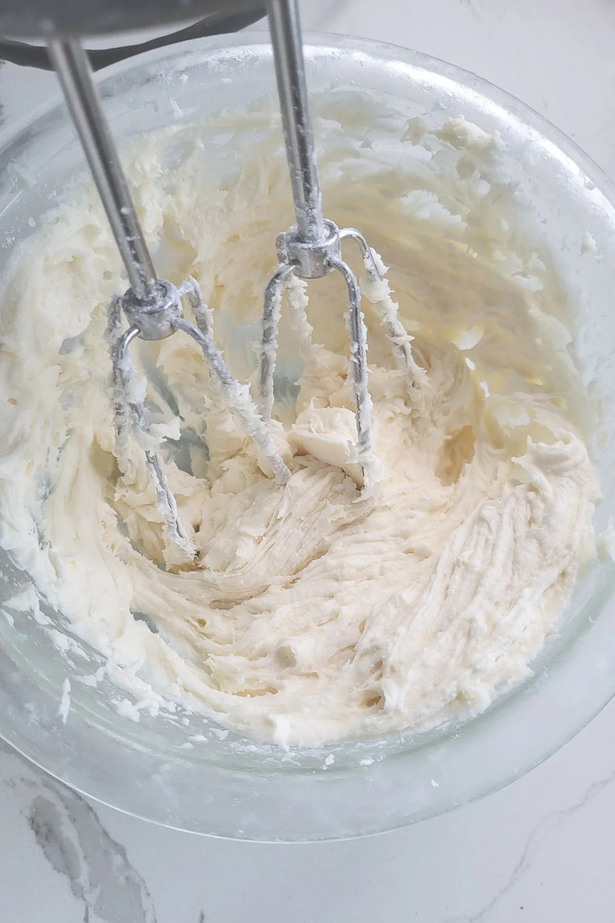 a bowl of frosting with beaters.