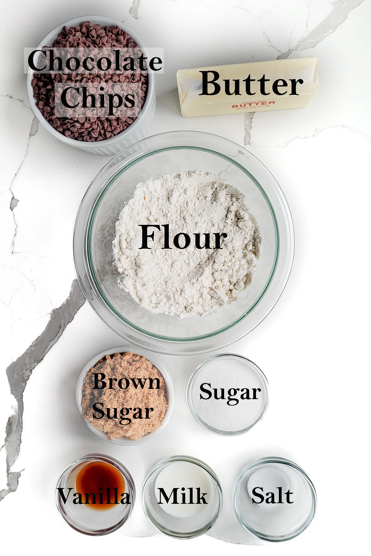 bowls of ingredients for cookie dough on a white surface.