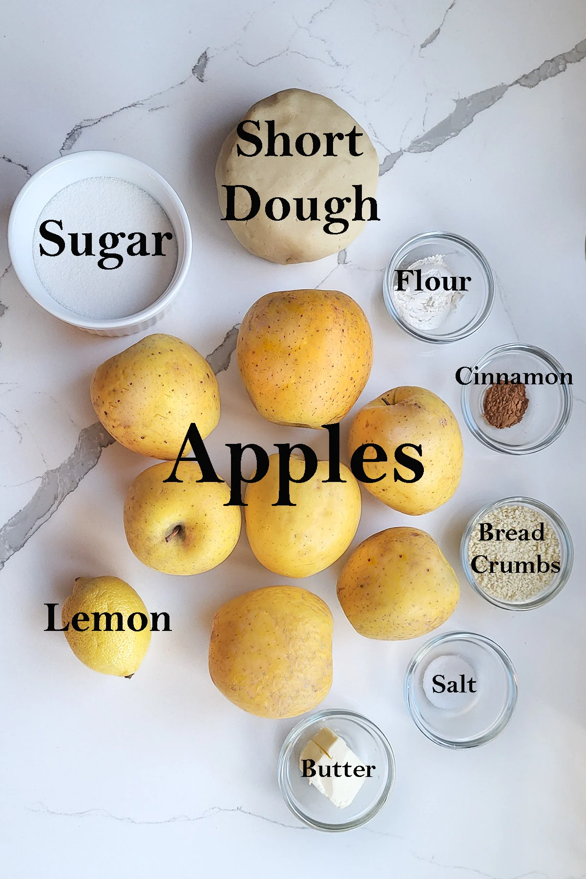 ingredients for making french apple tart on a white surface.