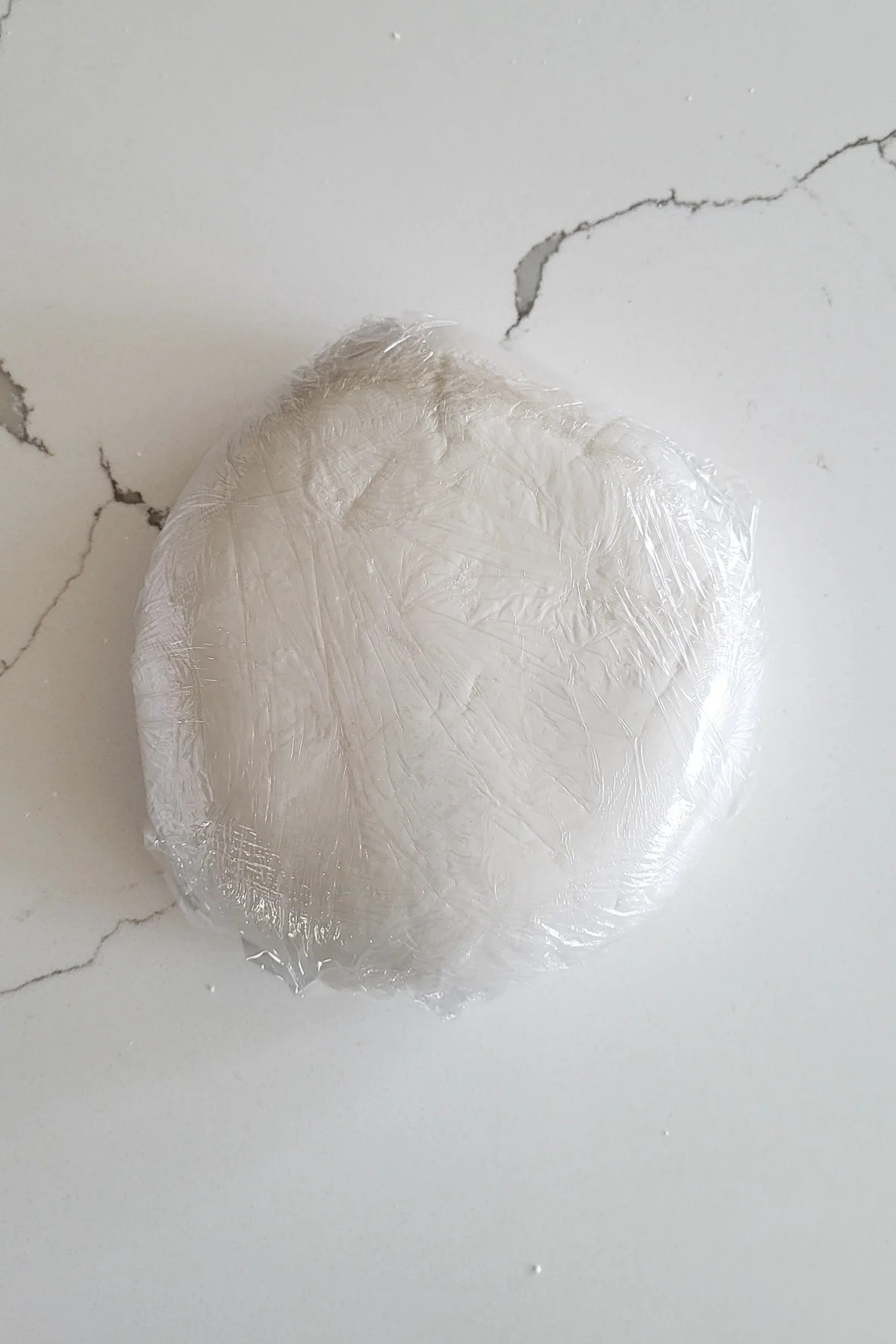 a piece of rolled fondant wrapped in plastic.
