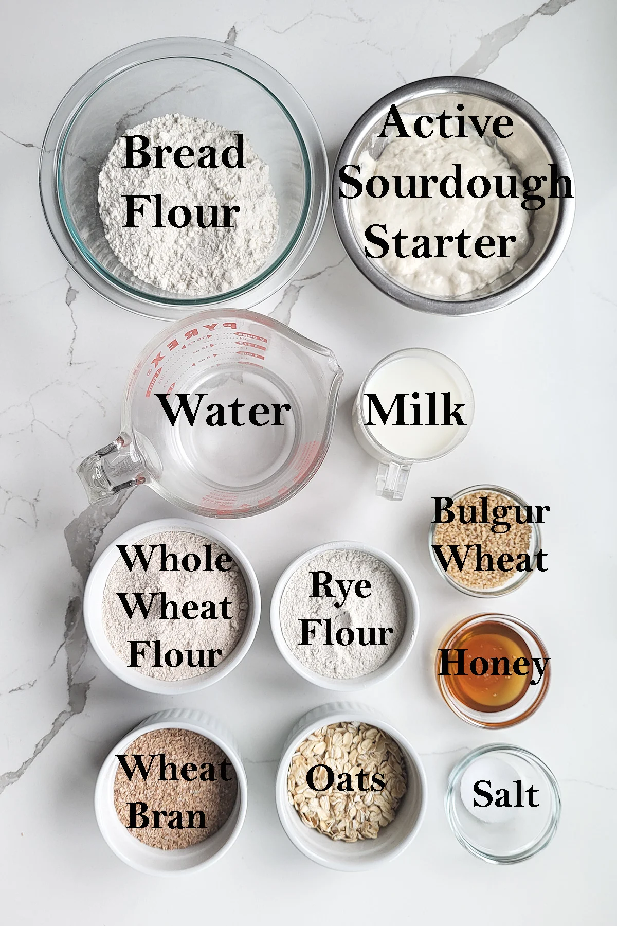 ingredients for sourdough multigrain bread arranged in bowls.