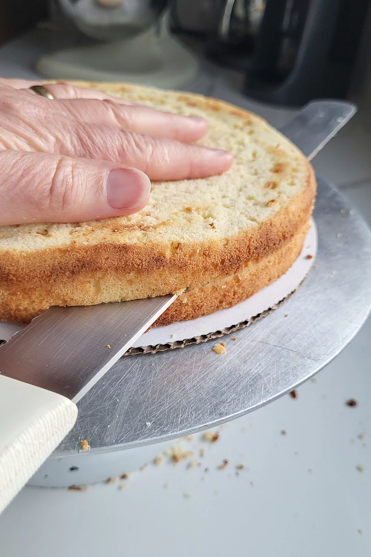 a knife splitting  a cake into 2 layers.