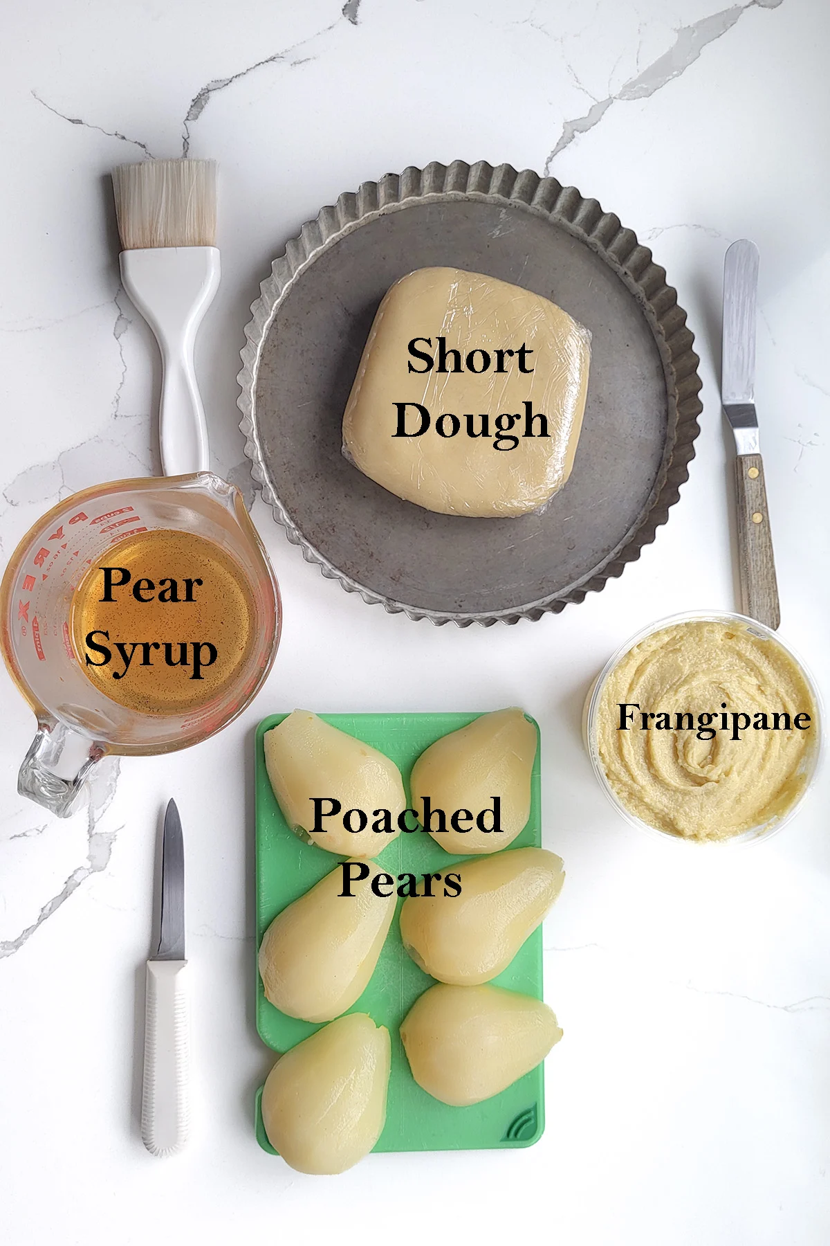Components of pear frangipane tart arranged on a table. Text overlay.