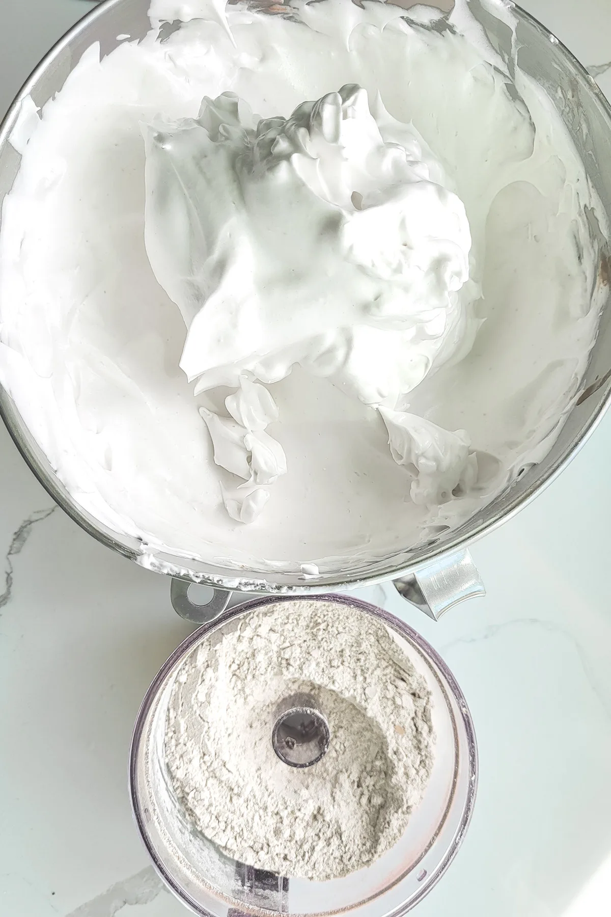 a bowl of egg whites and a bowl of flour.