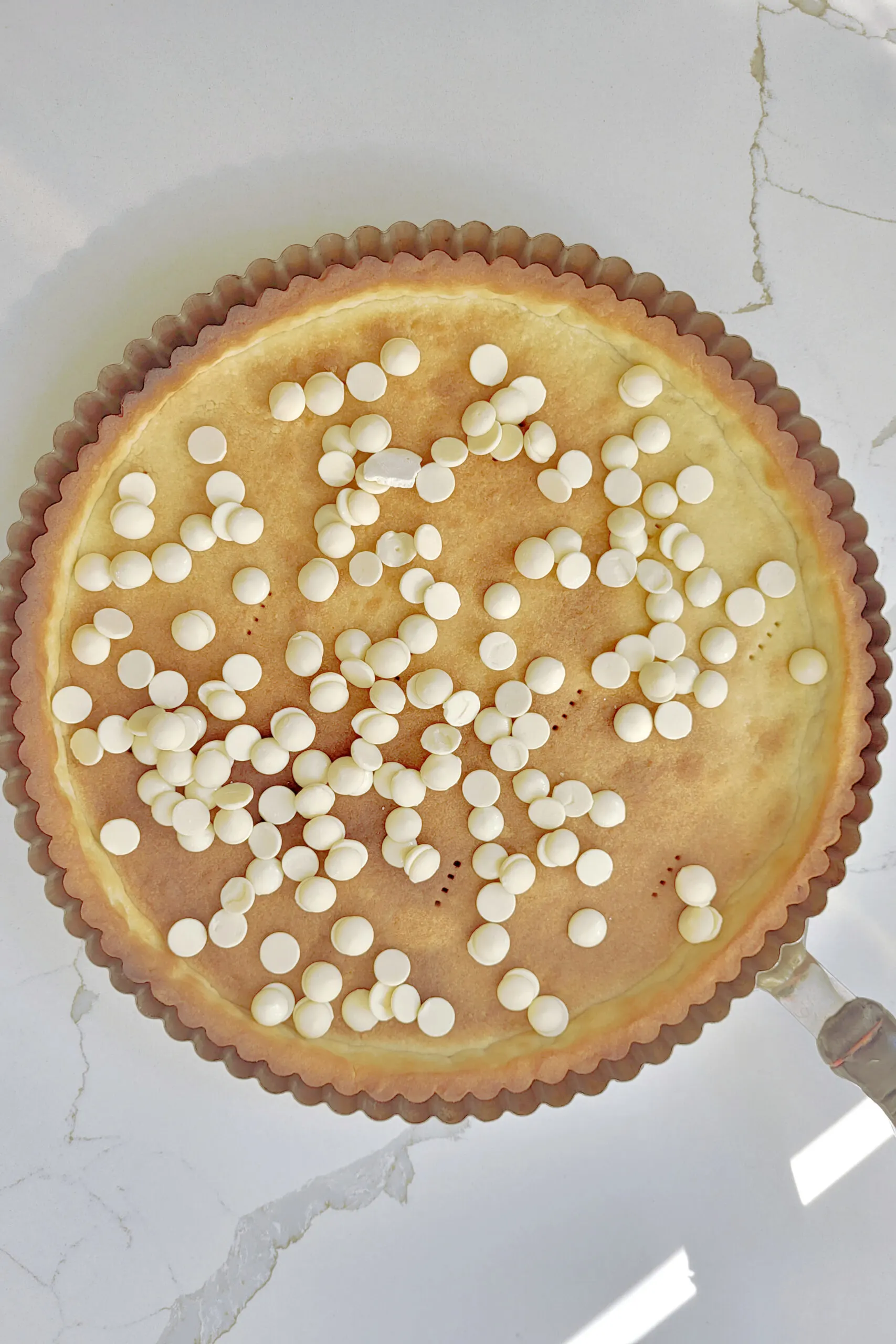 an empty tart shell with white chocolate chips.