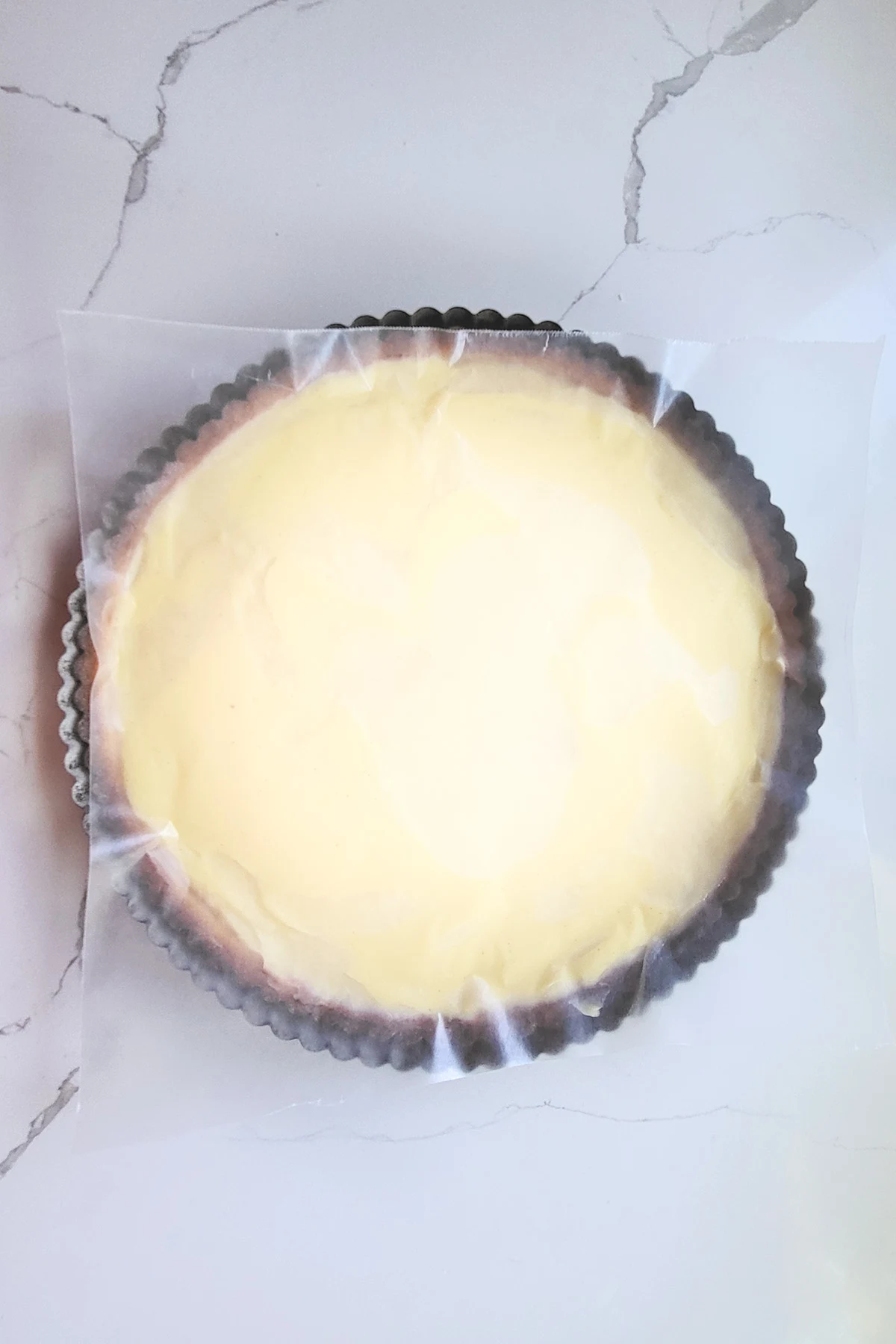 a tart shell filled with custard covered with wax paper.