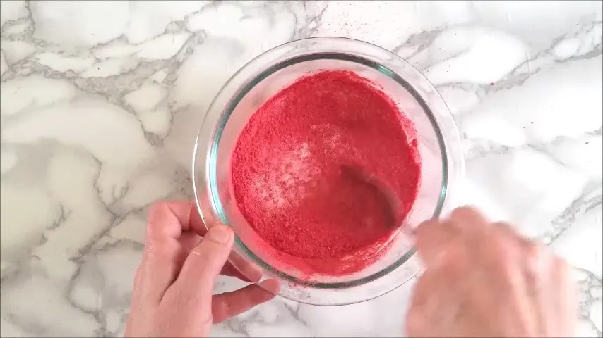 A bowl of strawberry sugar being stirred together.