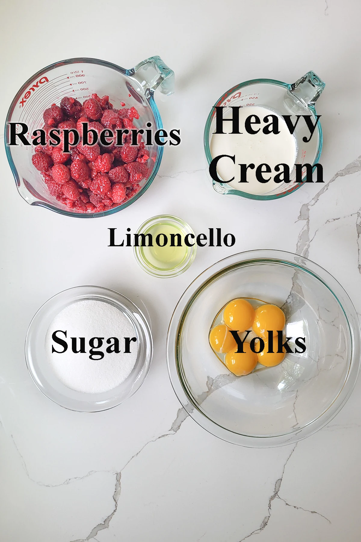 ingredients for raspberry ice cream in bowls with text overlay.