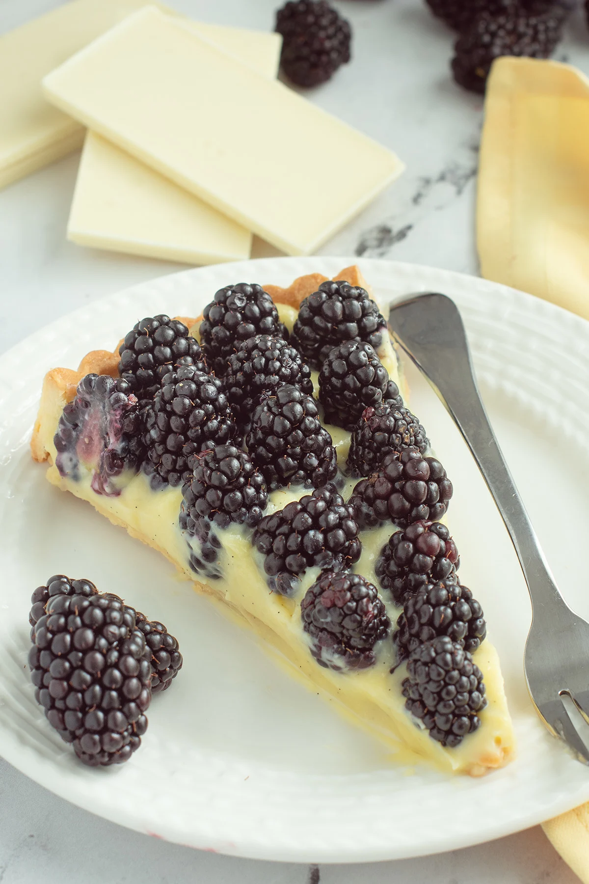 a slice of blackberry tart on a white plate.