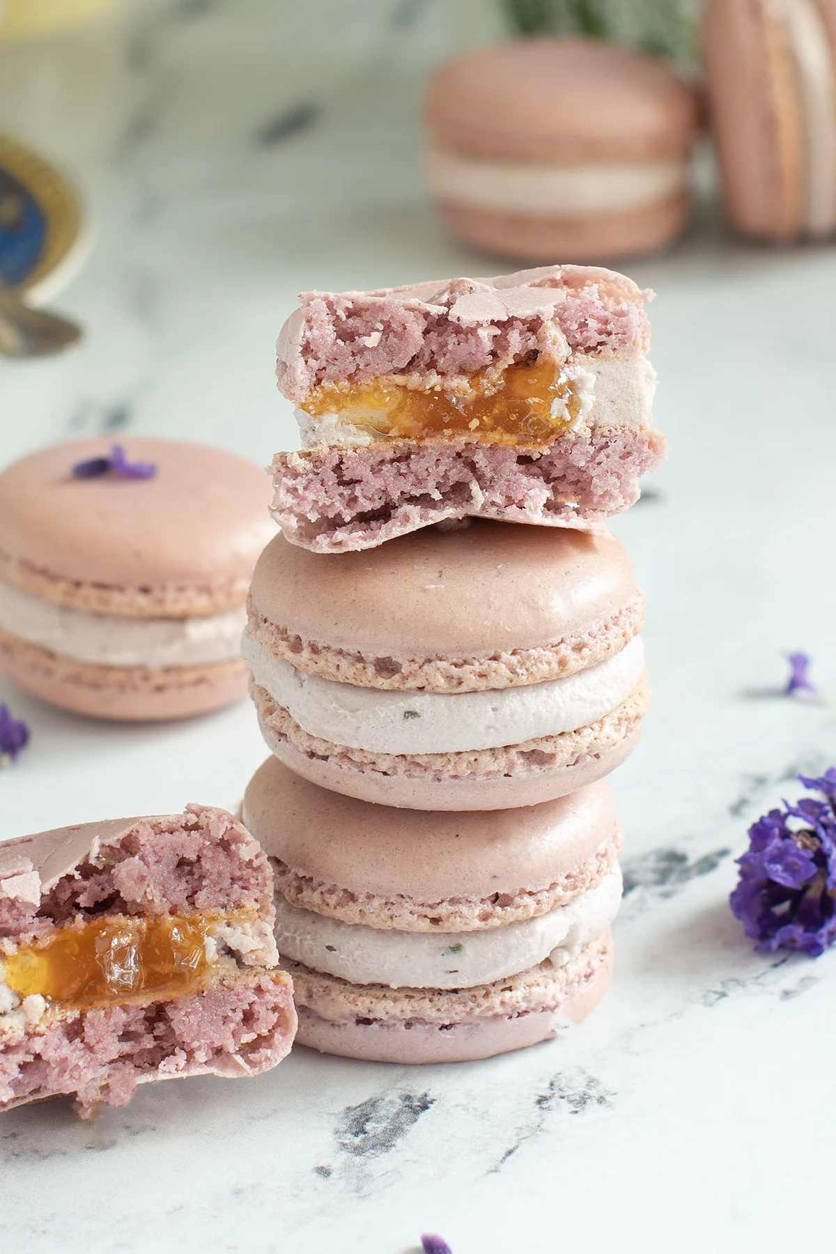 Stack of lavender macarons. Top one cut in half.