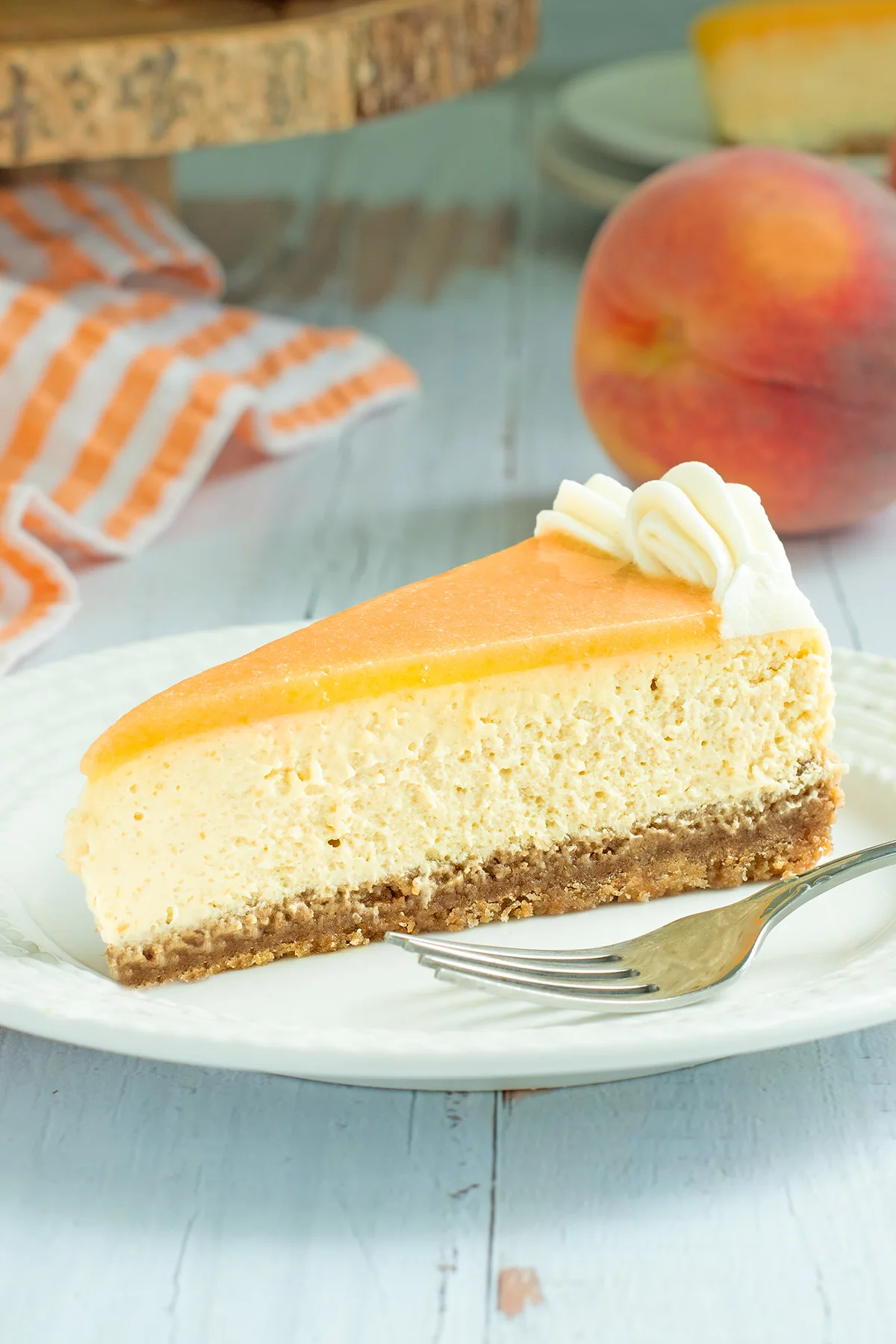 a slice of peach cheesecake on a white plate.