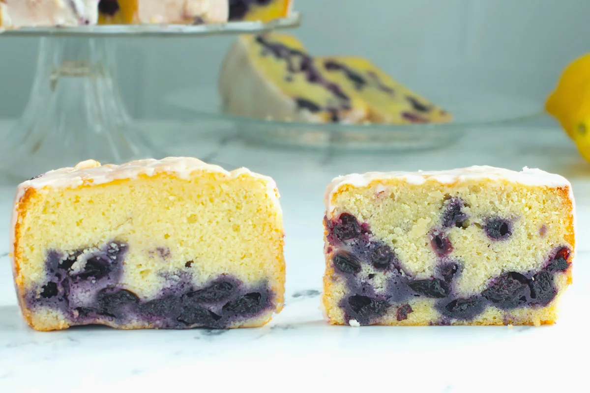 two slices of blueberry pound cake on a white surface.