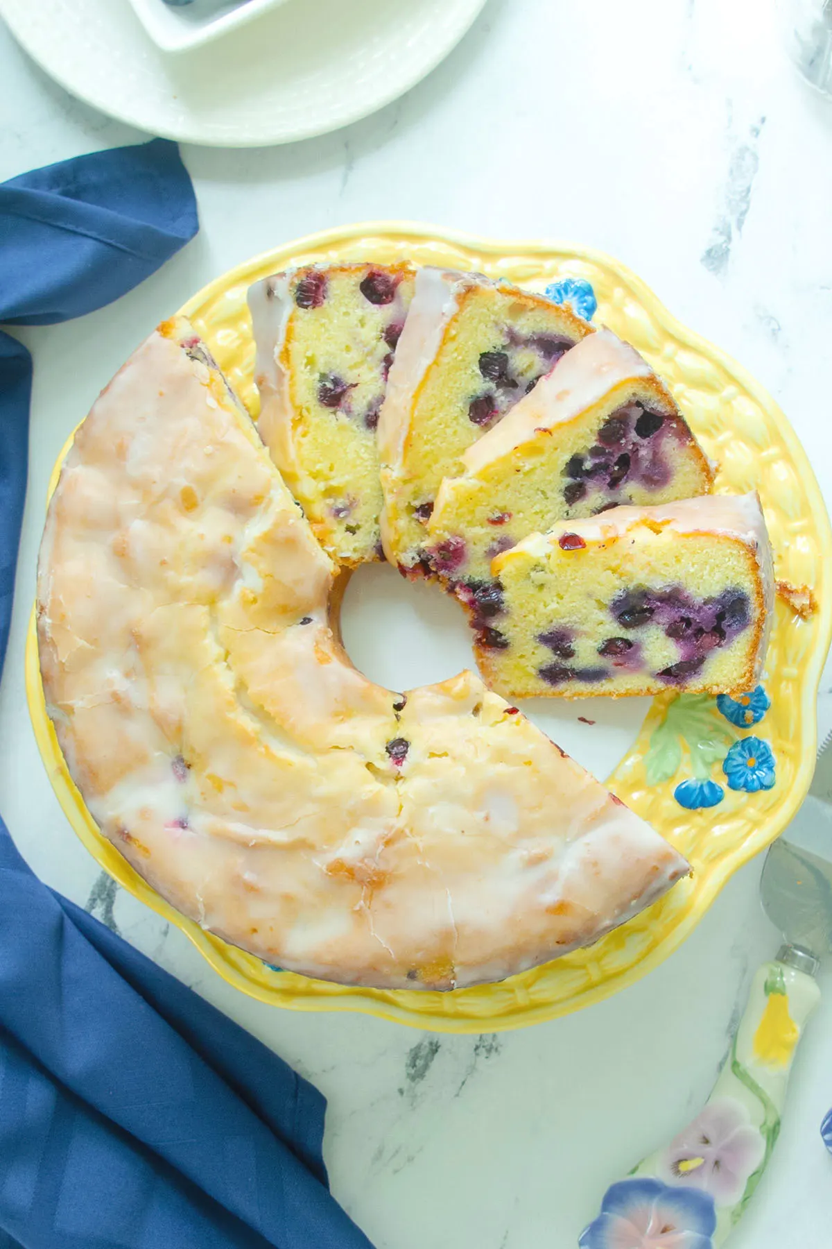 a blueberry pound cake on a decorative cake plate.
