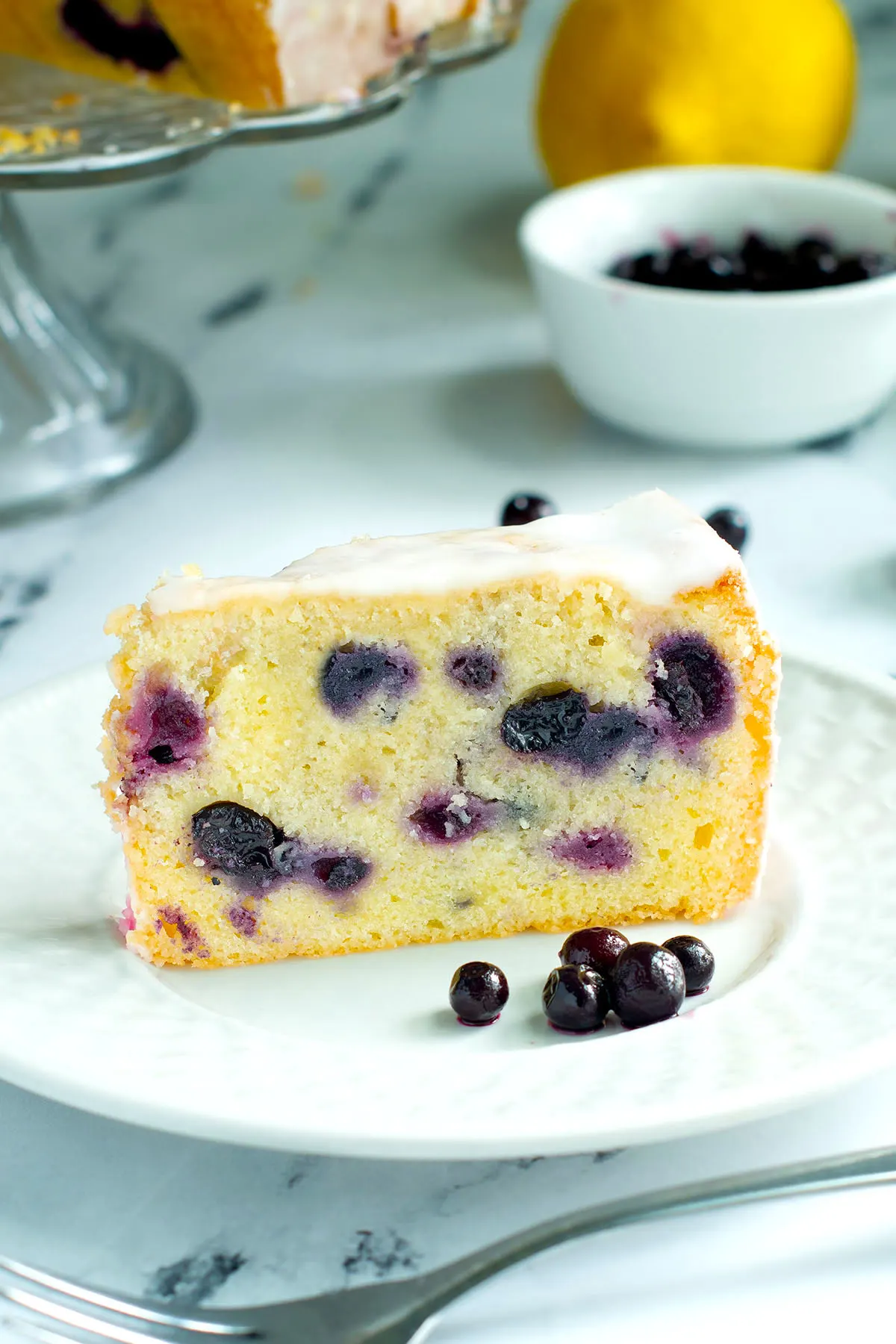 a slice of blueberry pound cake on a white plate.