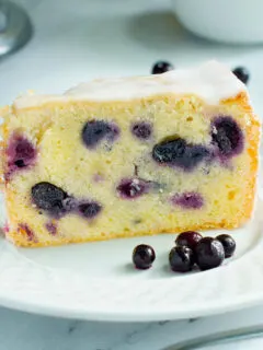a slice of blueberry pound cake on a white plate.