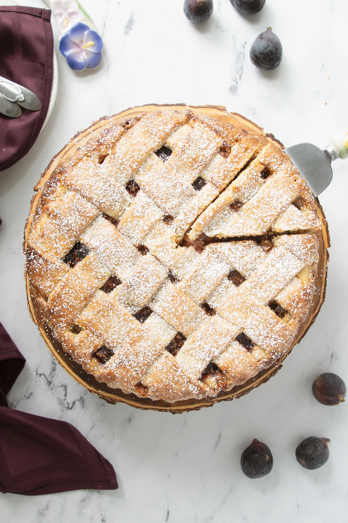 an overheat shot of a fig tart with a slice cut.