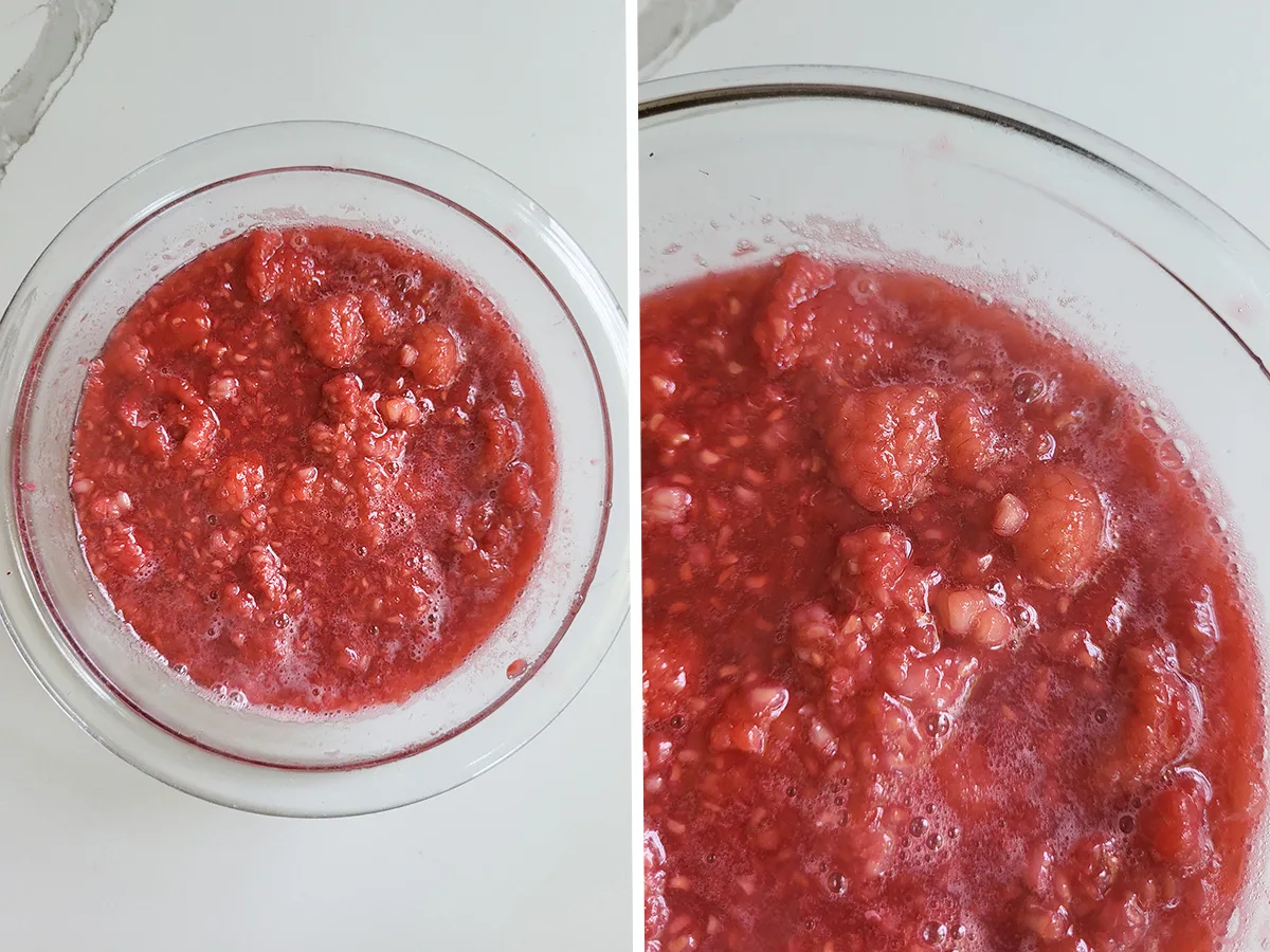 A glass bowl full of raspberry compote. Closeup of whole raspberries in bowl.