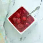 a bowl of raspberry compote with a spoon.