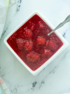 a bowl of raspberry compote with a spoon.