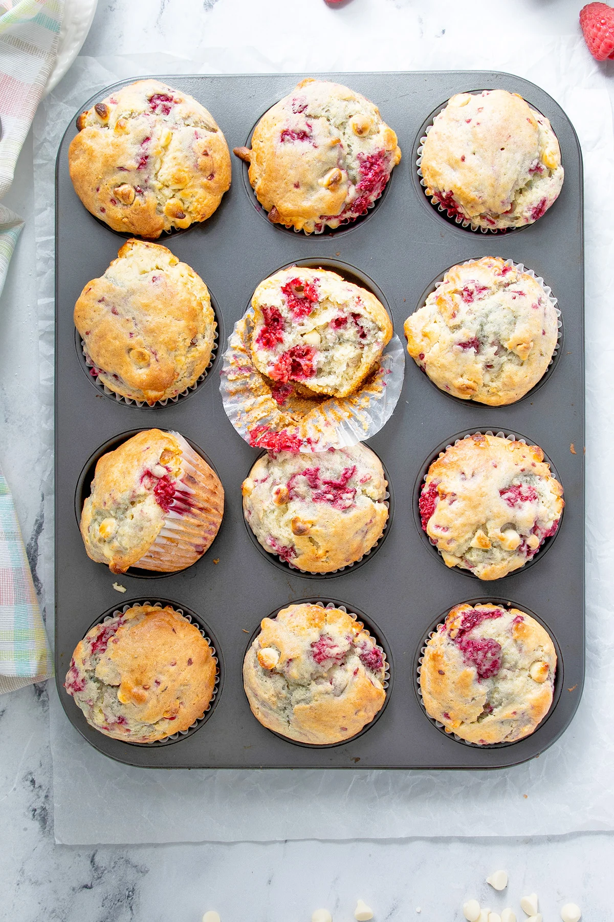 a muffin tin filled with raspberry muffins.