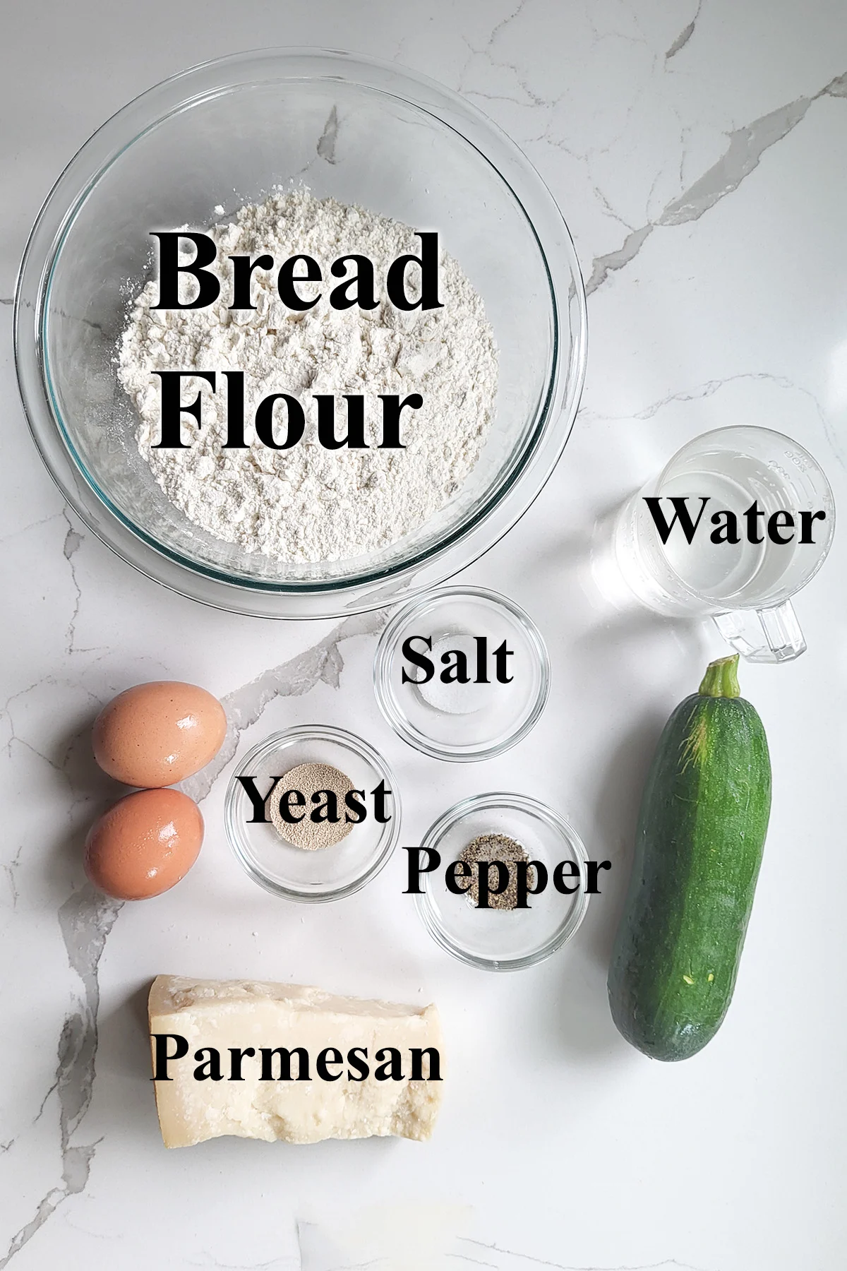 ingredients for zucchini yeast bread in glass bowls on a white surface.