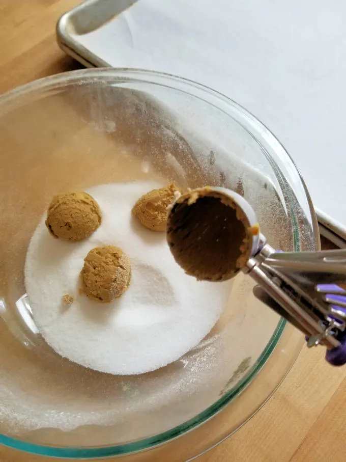 a bowl of sugar with cookie dough balls.