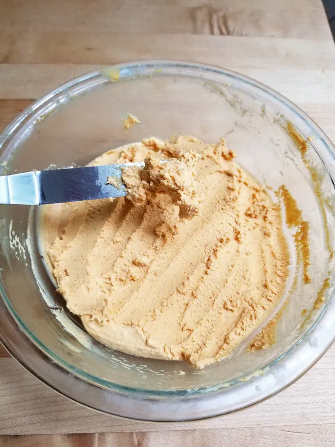 a glass bowl filled with orange colored ganache.