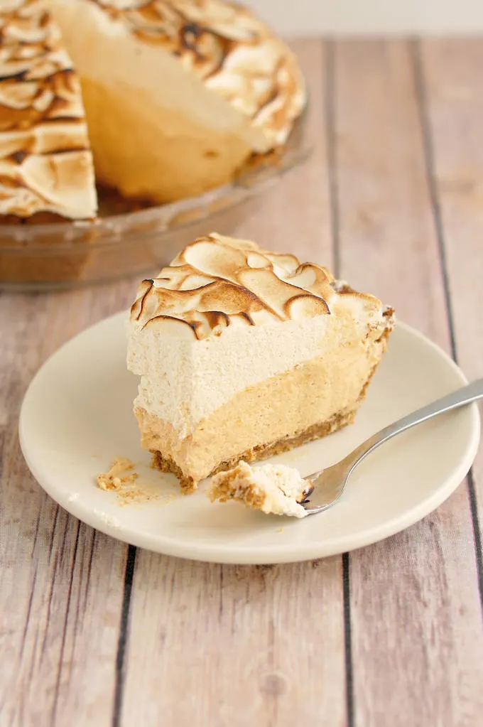 a partially eaten piece of pumpkin pie on a plate.