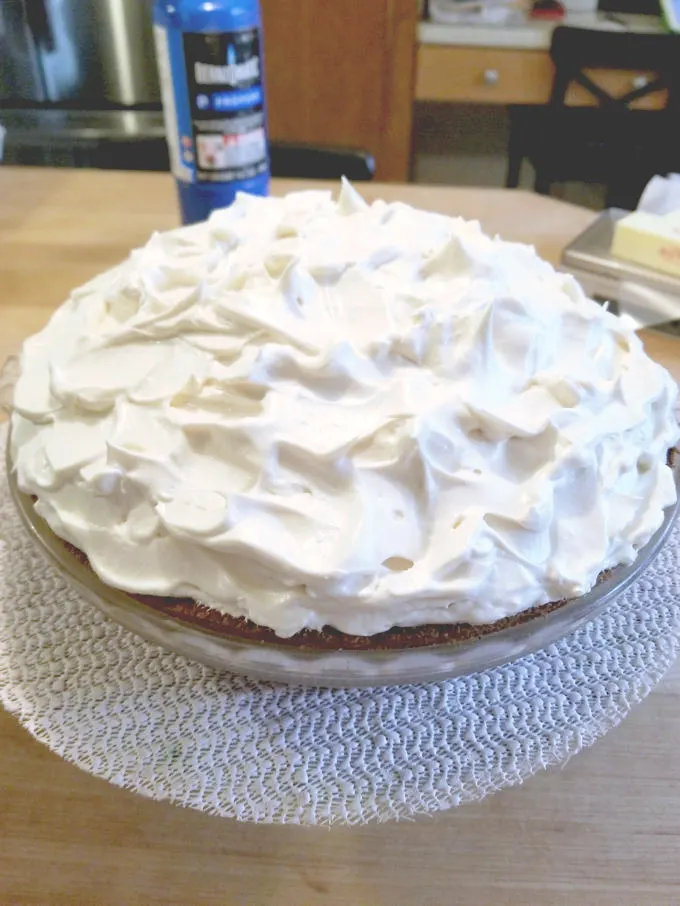 a meringue topped pie on a wood surface.