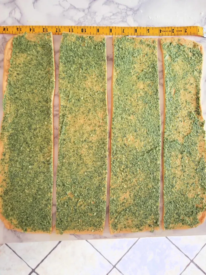 4 strips of dough covered with pesto.