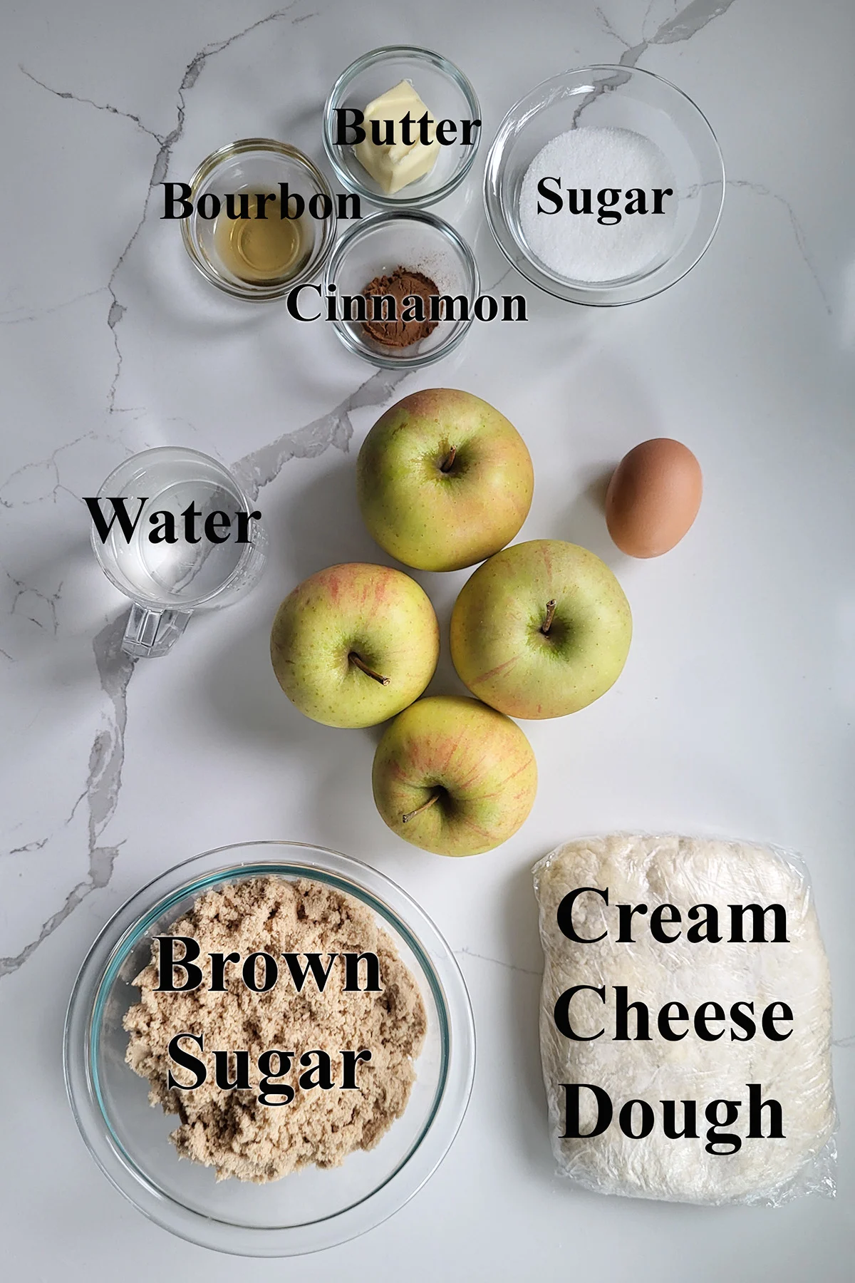 ingredients for apple dumplings in glass bowls on a white surface.