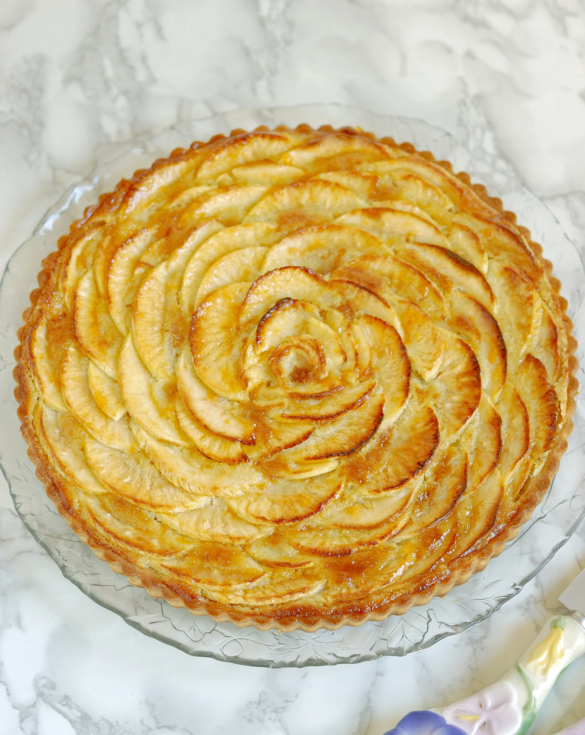 an apple tart on a glass plate.